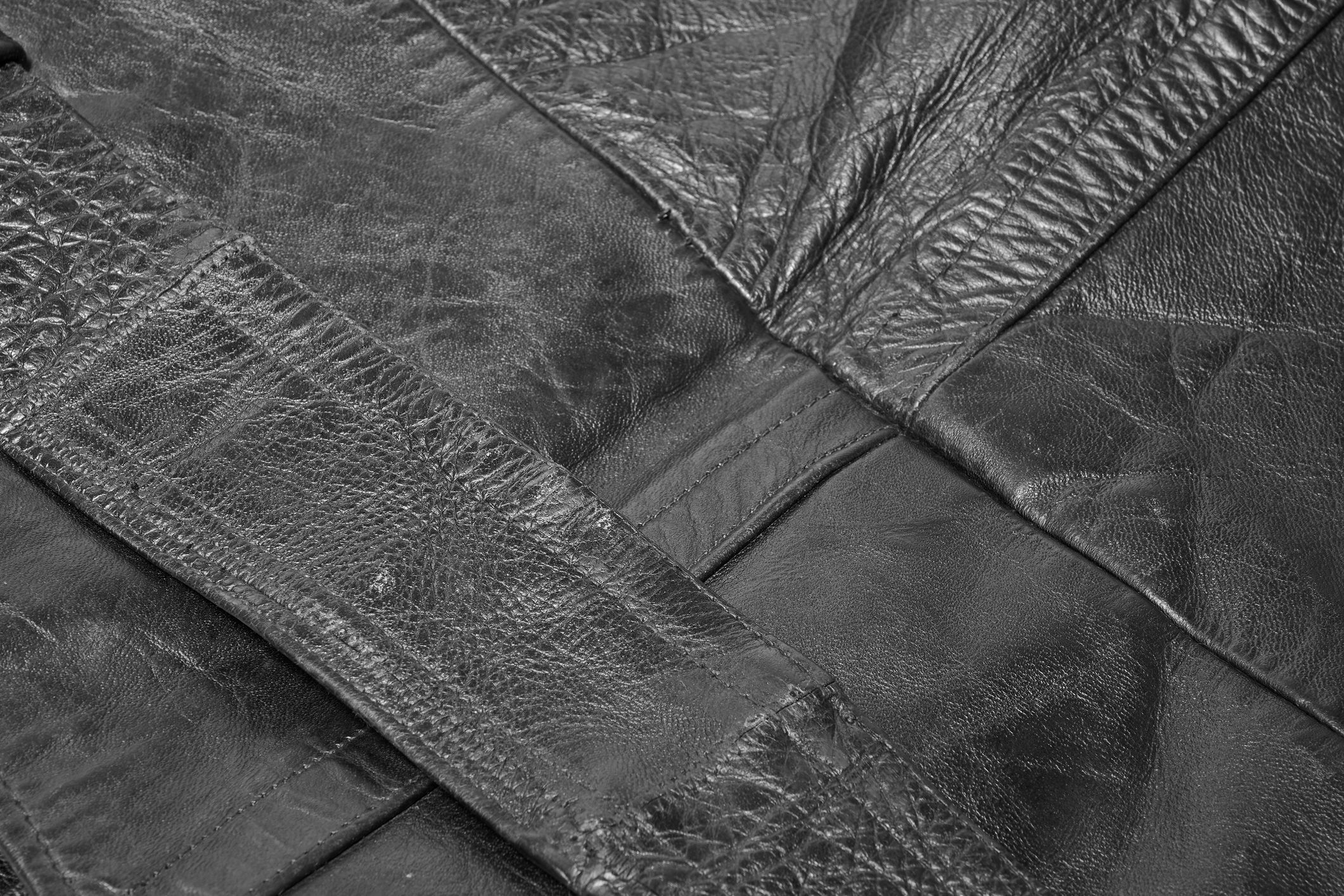Close-up of textured black leather patches stitched together.