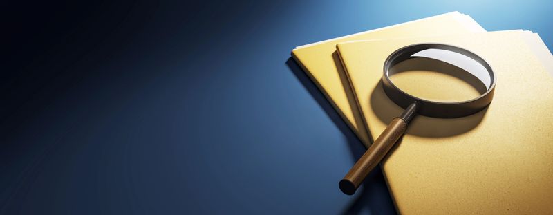 Magnifying glass on top of yellow folders on a blue desk background, 3D Rendering concept of investigation, research, and document inspection