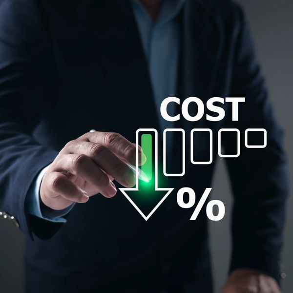 Businessman pointing at a glowing green arrow indicating cost reduction percentage.