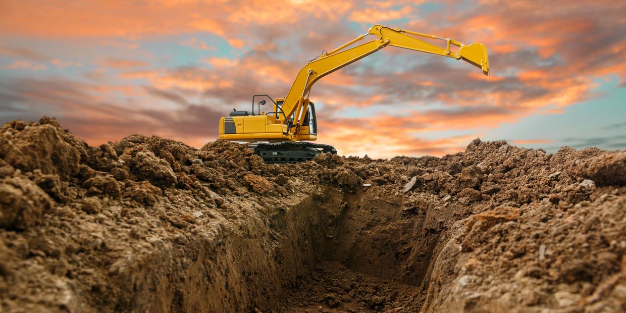 Excavator removing old concrete foundation during demolition in Naples, FL