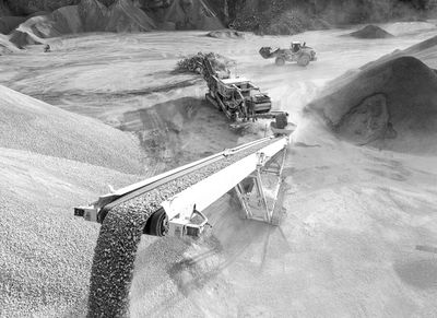 Conveyor belt transporting gravel at a quarry site.