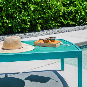 Poolside lounge chair with book, hat and sunglasses 