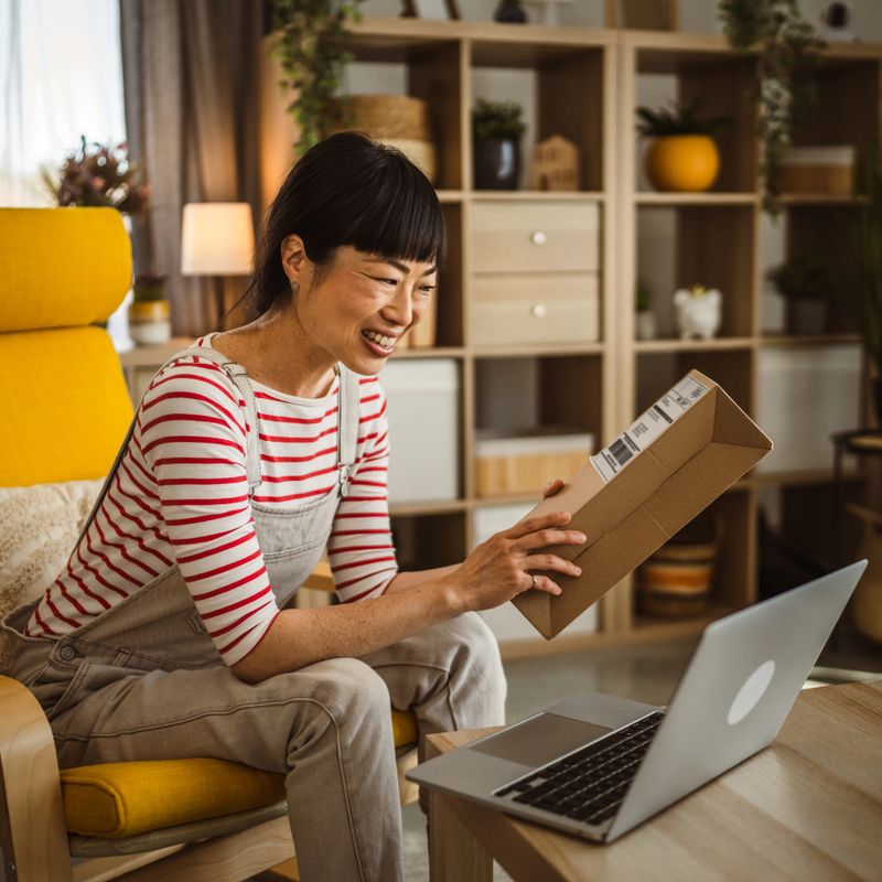 one japanese woman checking box of received package or product at home