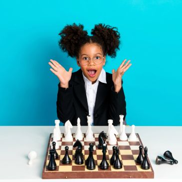 Excited girl playing chess.