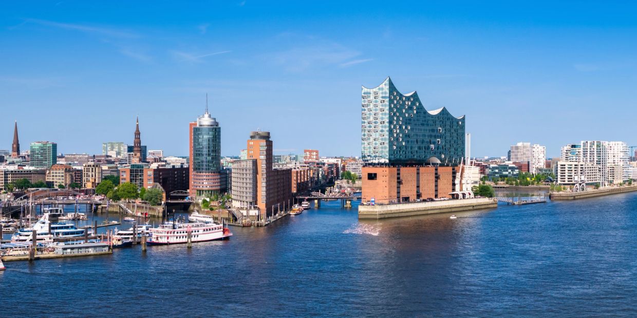 Blick auf die Elbphilharmonie in Hamburg am Flussufer bei klarem Himmel.