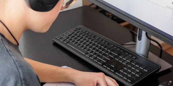 Person with headphones working at a computer.