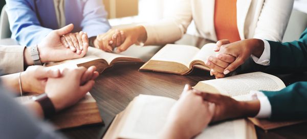 An open Bible with 2024 and a cross illuminated by sunlight.