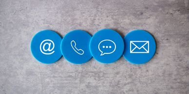 Blue icons representing email, phone, chat, and mail on a textured surface.
