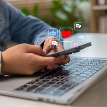 Person using smartphone with social media icons floating above.