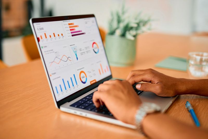 Businessman working on a laptop, analyzing vibrant sales and marketing data while reviewing colorful charts and graphs to drive informed decision-making and strategic planning