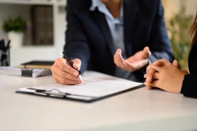 Two people in a discussion with paperwork on the table.