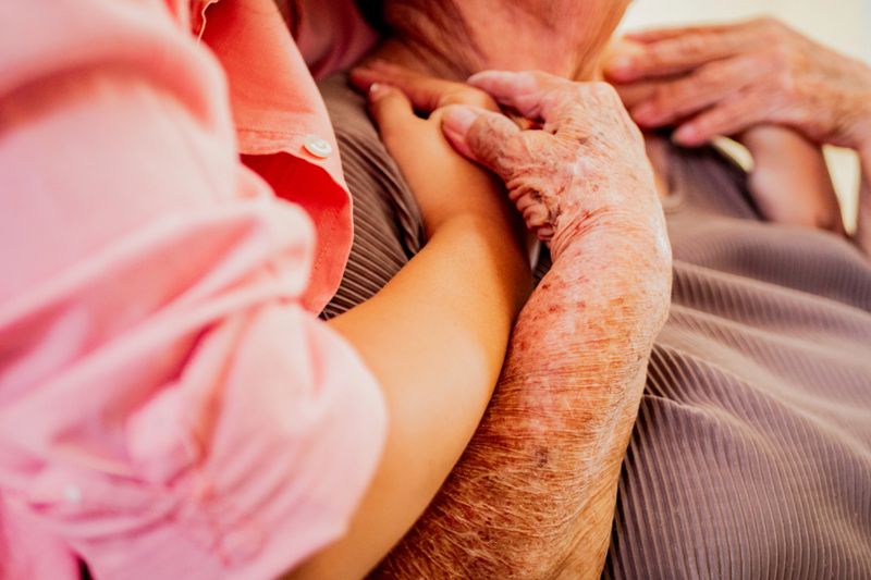 Close-up of granddaughter hands embracing grandmother