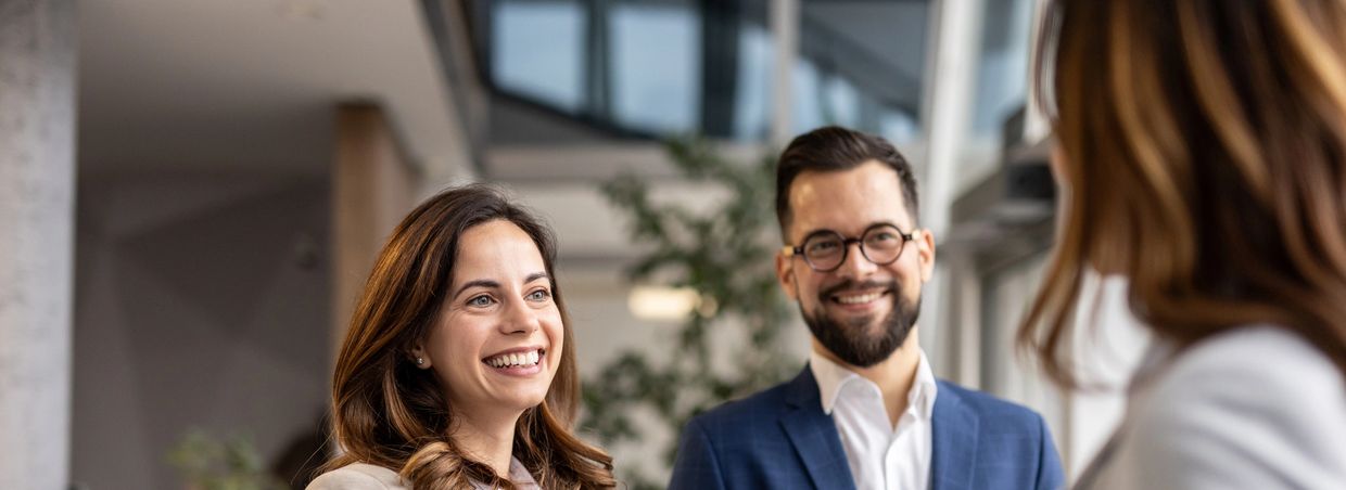 Two professionals smiling during a conversation.