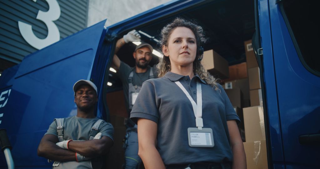 Delivery team posing confidently in front of a van.