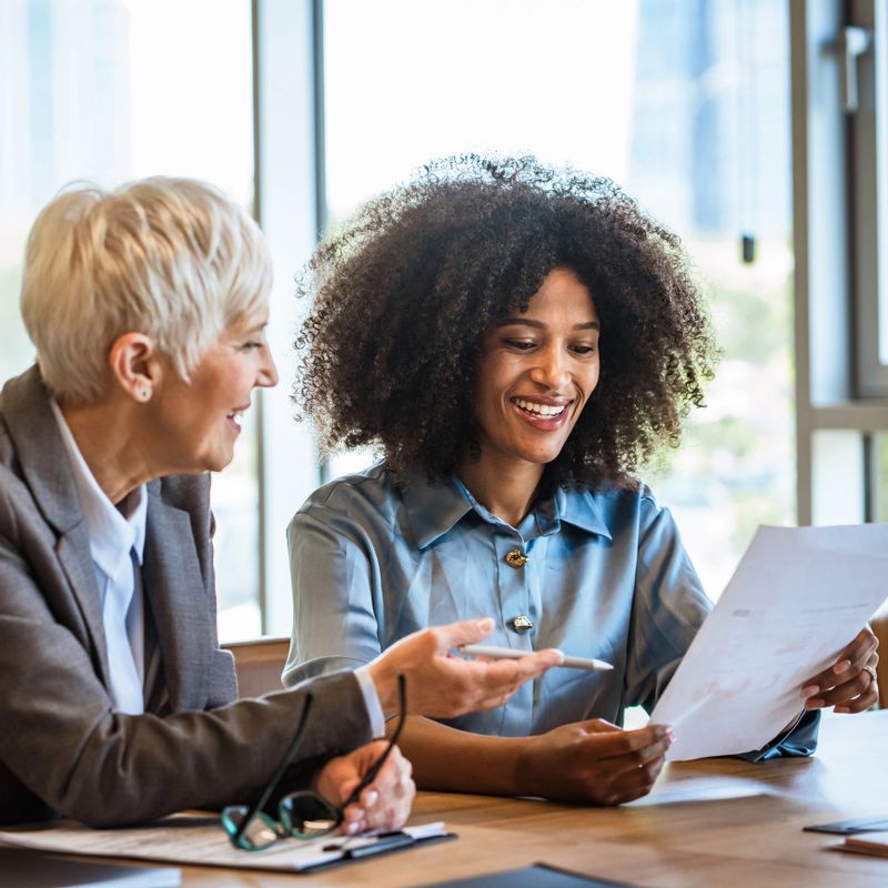 diverse multicultural businesswoman on the meeting in modern office, smiling colleagues discussing ideas at work, taking notes and during productive business meeting
