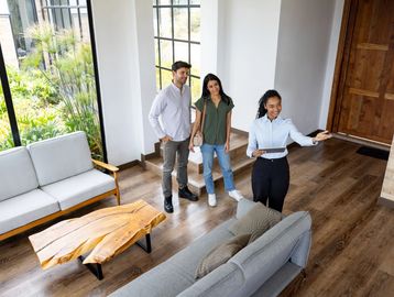 Real estate agent showing a couple a modern living room.