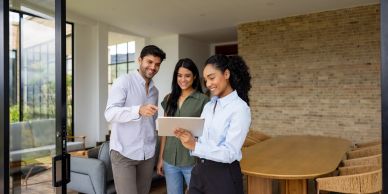 Three people using a tablet indoors.
