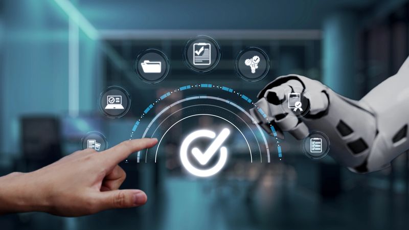 A human hand reaches toward a robotic hand in a futuristic office environment, showcasing interaction with a digital interface symbolizing modern technology and innovation. Auvana