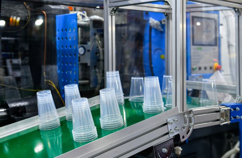Plastic cup on conveyor belt in distribution warehouse. parcels transportation system concept.