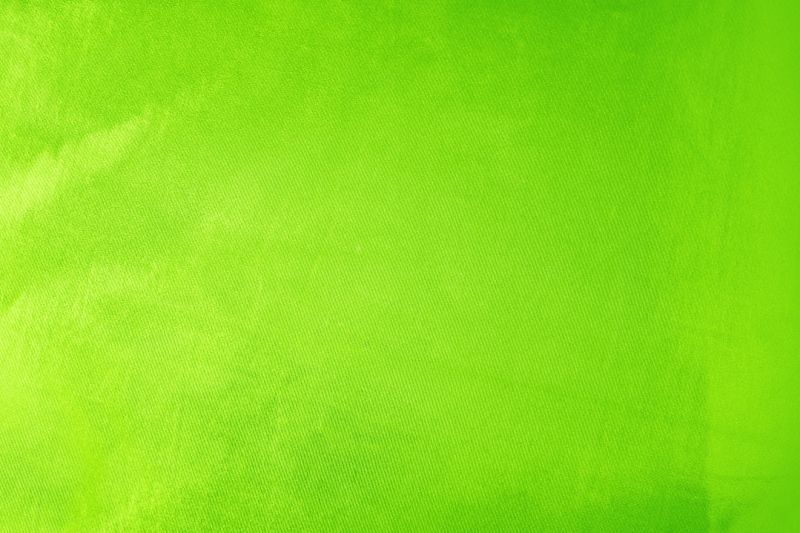 Yellow green lemon lime chartreuse abstract background. Light bright vivid vibrant metallic neon electric shade color. Toned surface of shiny fabric. Blank. Design.
