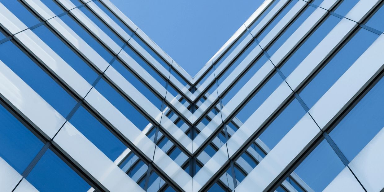 Modern glass building reflecting another structure.