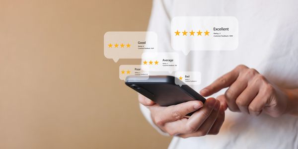 Person holding smartphone with floating star ratings and reviews.