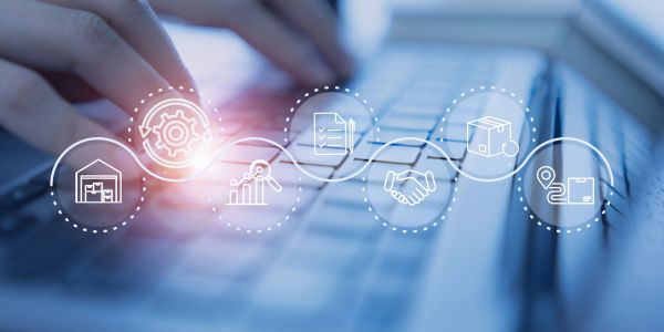 Hands typing on a keyboard with digital business icons overlayed.