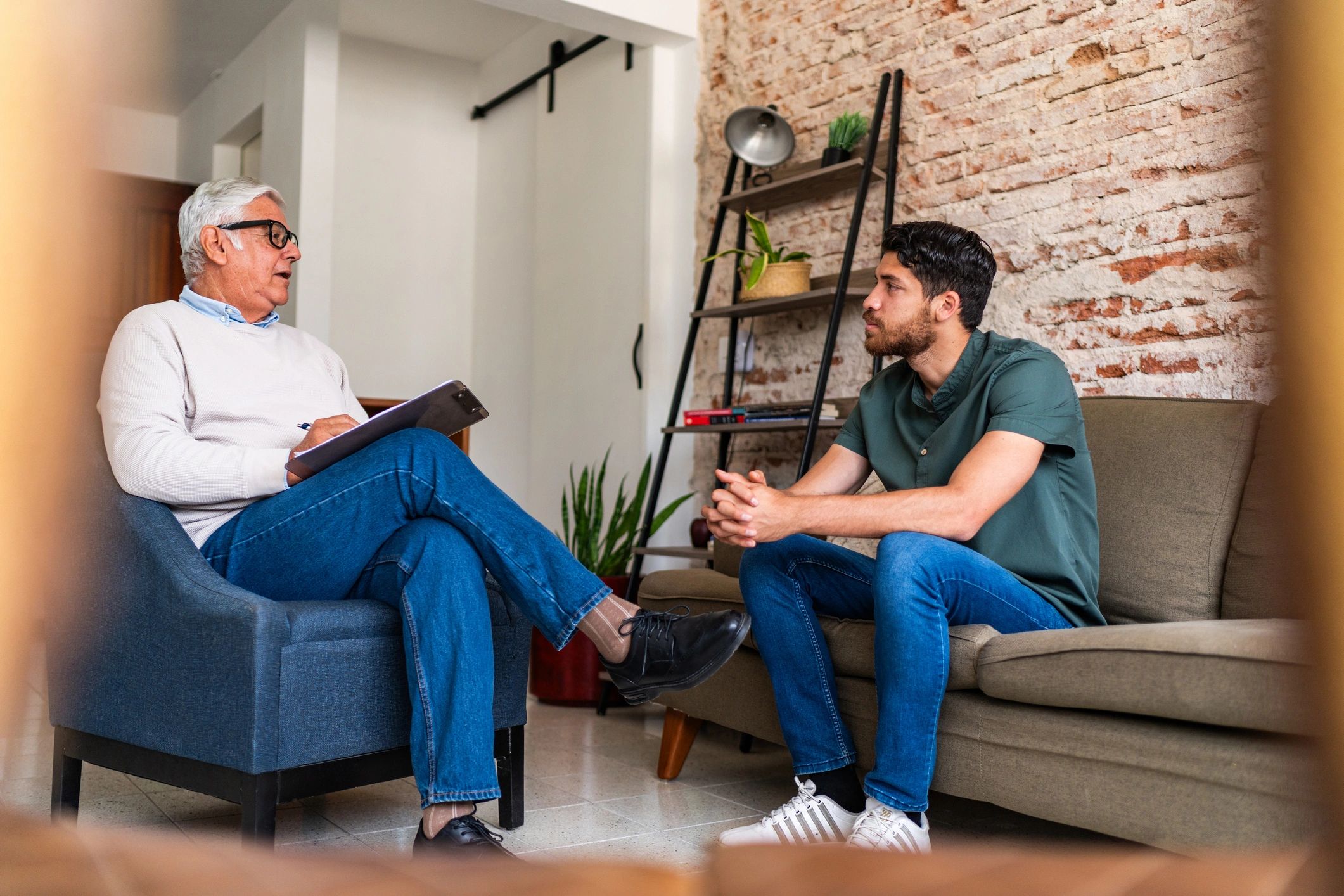 Two men having a serious conversation in a cozy room.