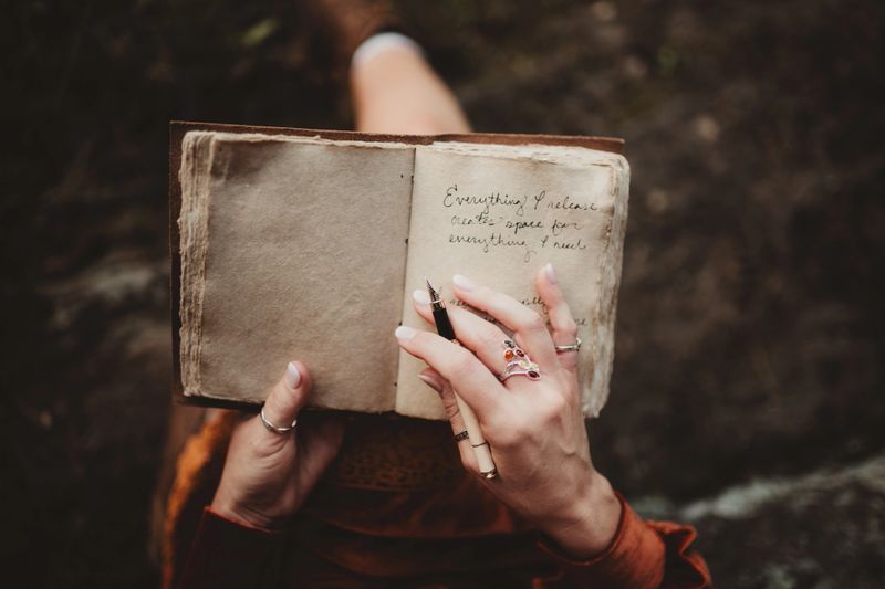 Woman sitting outdoors writing in her journal or diary