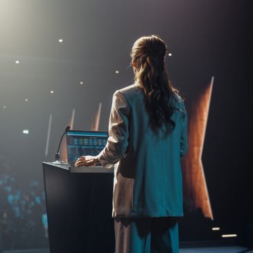 Woman giving a presentation on stage.