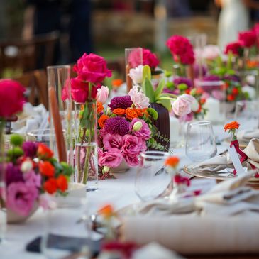 Elegant table setting with vibrant floral centerpieces for a celebration.