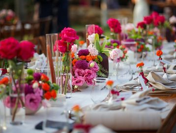 Elegant table setting with vibrant floral centerpieces for a celebration.