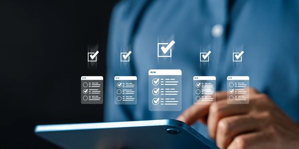 Person using tablet with digital checklist icons floating above.