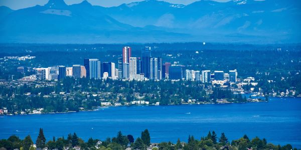 Bellevue city skyline across Lake Washington with Cascade Mountains in the background on a clear day