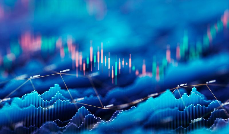 Dynamic abstract image of financial data and stock market analysis, featuring colorful candlestick charts and digital data graphs in a futuristic blue-toned background. Represents investment trends, trading strategies, and financial technology concepts.