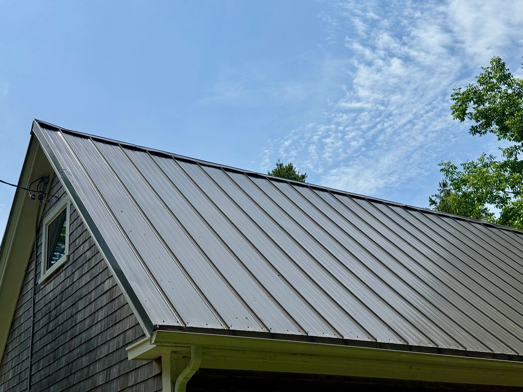 House with a metal roof and blue sky.