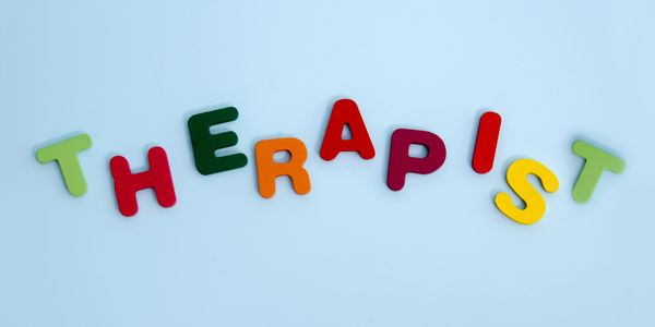 Colorful letters spelling the word 'THERAPIST' on a light blue background.