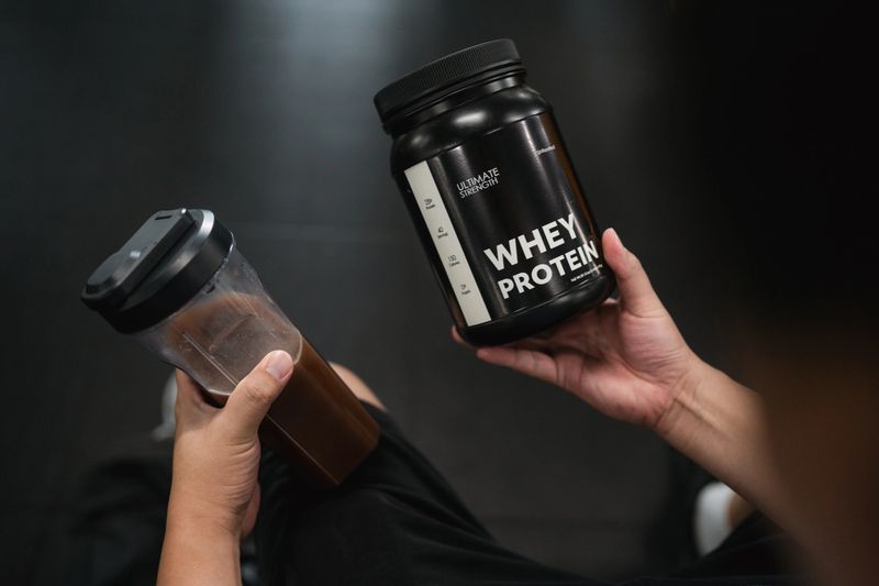 Plus-size man drinking whey protein shake, sitting confidently on a bench after a workout session, refueling his body with the nutrients it needs to recover and grow stronger