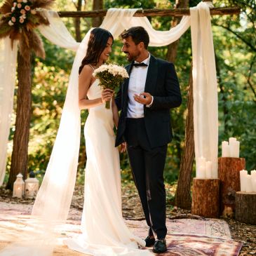 Bride and groom sharing a joyful moment during outdoor wedding ceremony.