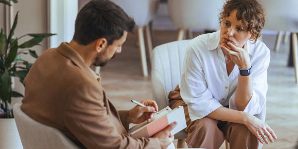 Woman consulting a male therapist in a cozy office.