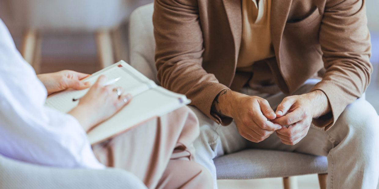 Two people having a focused conversation, one taking notes.