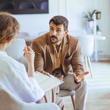 A man discusses something earnestly with a woman taking notes in a modern office.