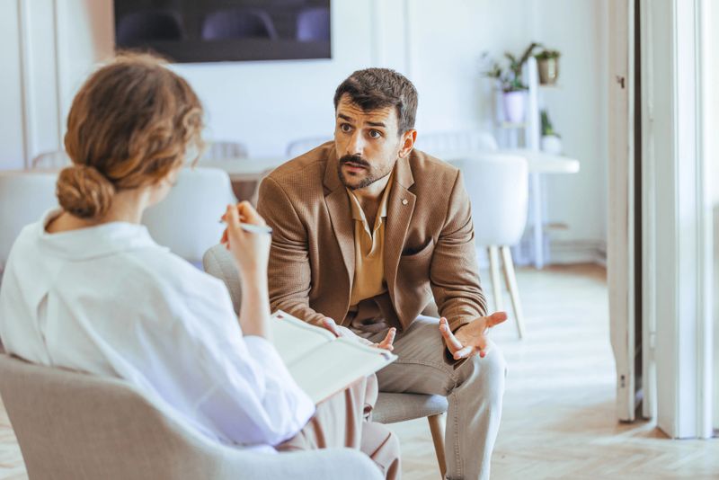 Focused discussion at a consultation between a professional therapist and a client in a modern, bright office. Vibrant exchange showcasing support, understanding, guidance, and verbal communication.