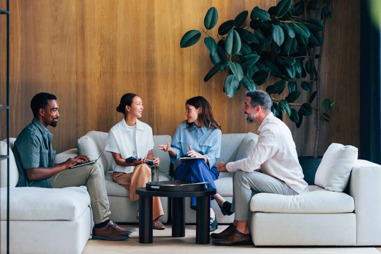 Diverse group having a casual meeting in a modern office lounge.