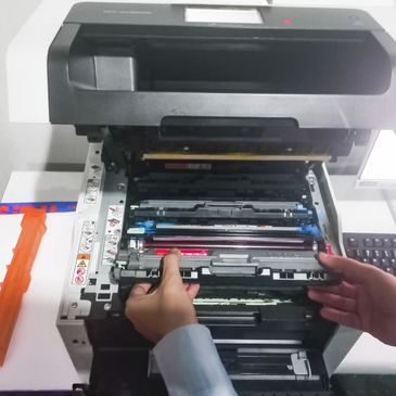 Person repairing or replacing toner cartridge in a printer.