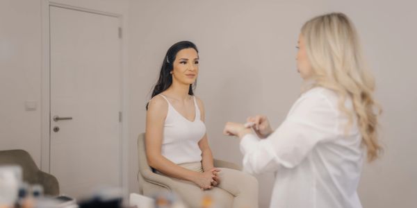 Woman getting makeup applied in a studio.