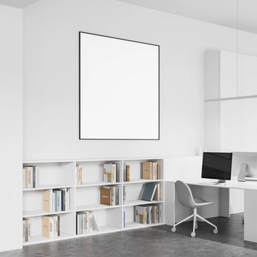 Minimalist white office with bookshelf, computer, and blank wall art.