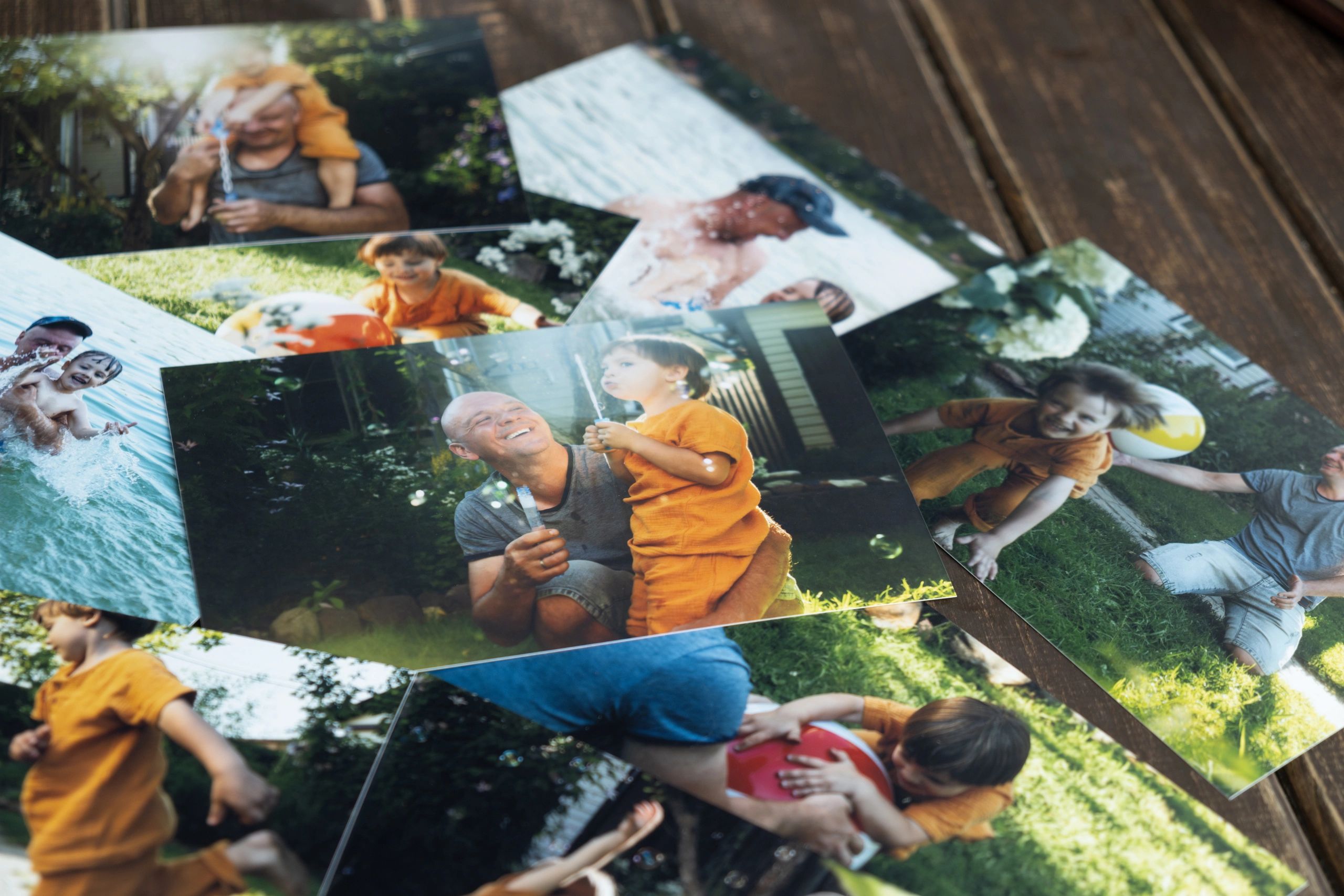 Printed photos of father and child playing outdoors.