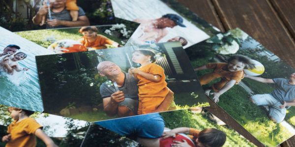Collection of family photos scattered on a wooden surface.