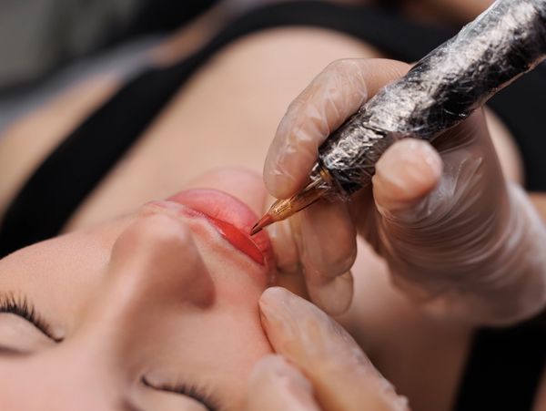 Close-up of lip tattooing procedure.